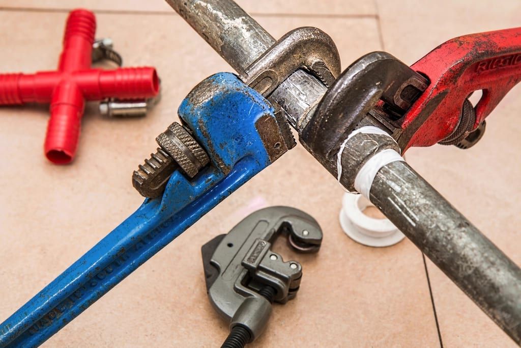 Two pipe wrenches gripping a steel pipe